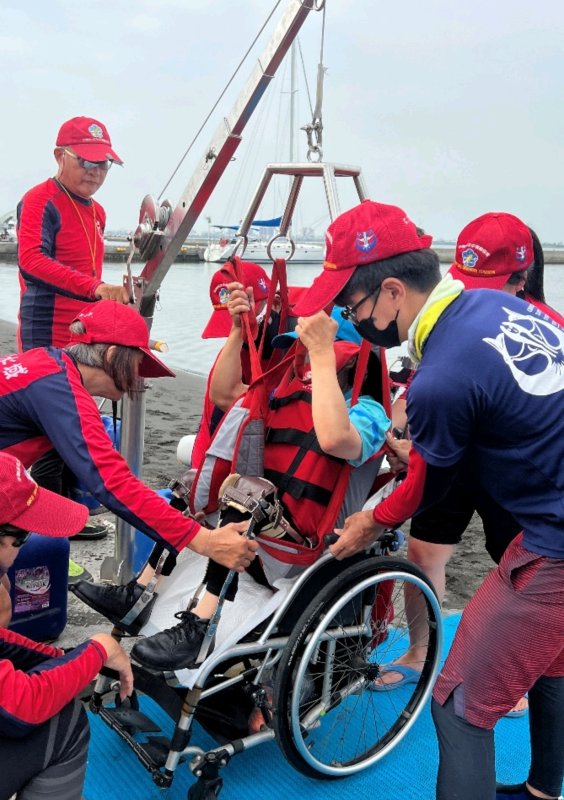 志工與教練合力操作移位機，讓身障學員在穩定支撐下安心入海。每一次轉移，都是一次勇氣的啟程。