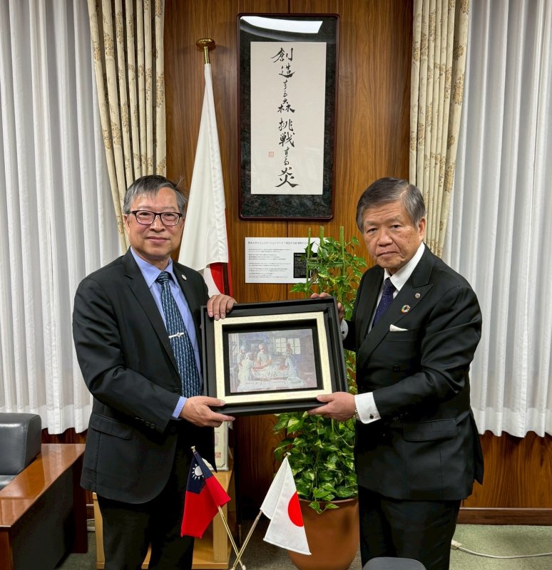 高雄醫學大學校長余明隆(左)致贈代表高醫大精神的割膚之愛畫作予熊本大學校長小川久雄 (右)。