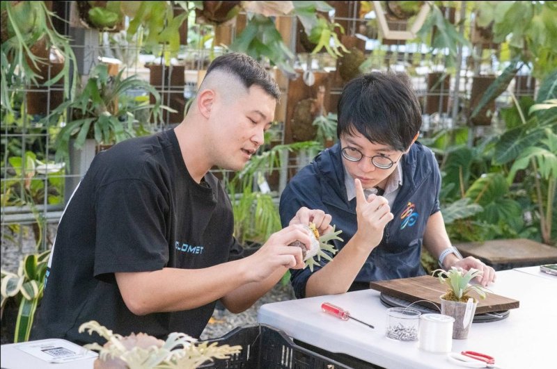青年局局長林楷軒(右)在「阿金的便秘花園」負責人宋致穎(左)的介紹下親自體驗DIY上板的全過程，並了解鹿角蕨的結構與植物特性。