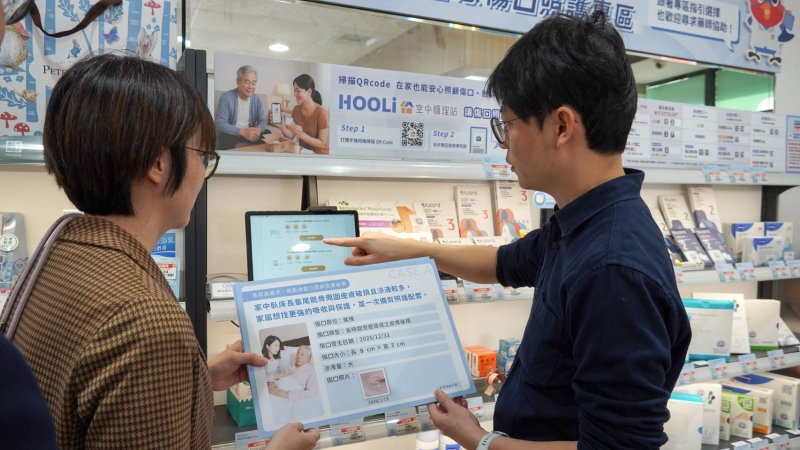 青年局長林楷軒(右)操作「HooLi空中護理站」系統，以瞭解如何透過平板精準配對符合需求的傷口敷料與照護建議。