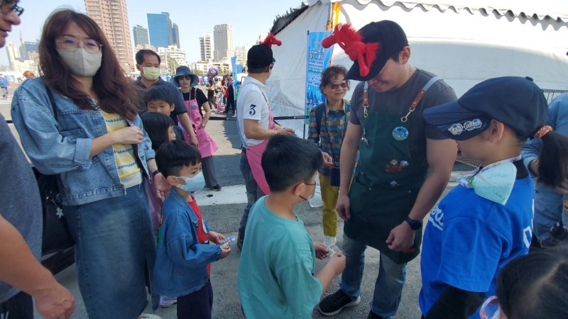 冬日遊樂園寫生首日，教育局長吳立森協同副局長劉靜文、社教科長李靖葦、新上國小校長王彥嵓發送超人力霸王小禮物，親子爭相索取，現場熱鬧滾滾。（漾新聞記者陳雯萍攝）