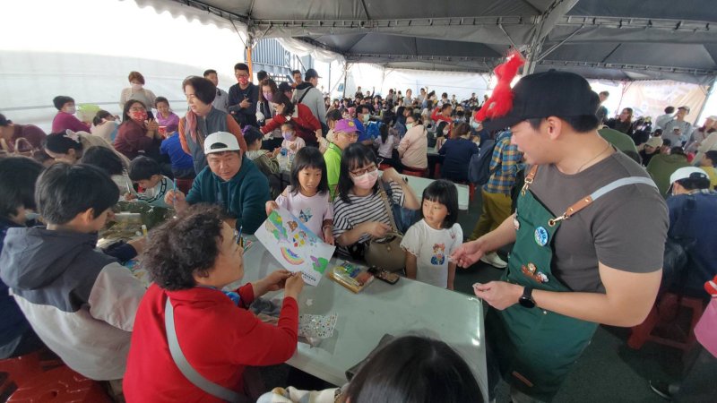 冬日遊樂園寫生首日，教育局長吳立森協同副局長劉靜文、社教科長李靖葦、新上國小校長王彥嵓發送超人力霸王小禮物，親子爭相索取，現場熱鬧滾滾。（漾新聞記者陳雯萍攝）