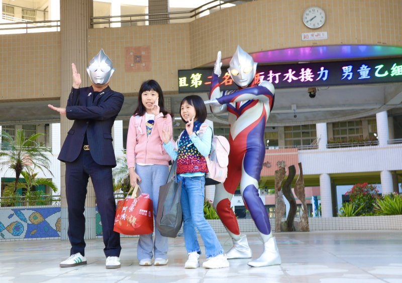 校長王彥嵓與家長會長、蘇守懌及師長家長扮演的超人力霸王，在校門口迎接學生開學。（漾新聞記者陳雯萍攝）