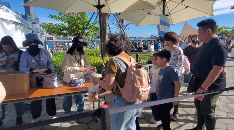 觀光局在閉幕式中加碼贈送的超人頭盔，民眾攜家帶眷排隊，再度蔚成盛況。(漾新聞記者陳雯萍攝)
