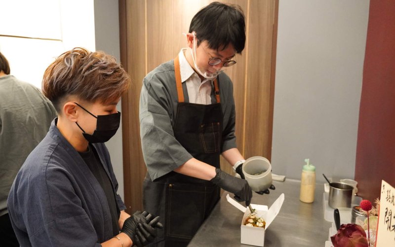 青年局長林楷軒(右) 在「囍丸」創辦人李佩縈（左）的解說下，了解抽象的品牌理念融入產品製作，打造出極具市場競爭力的獨特風格。