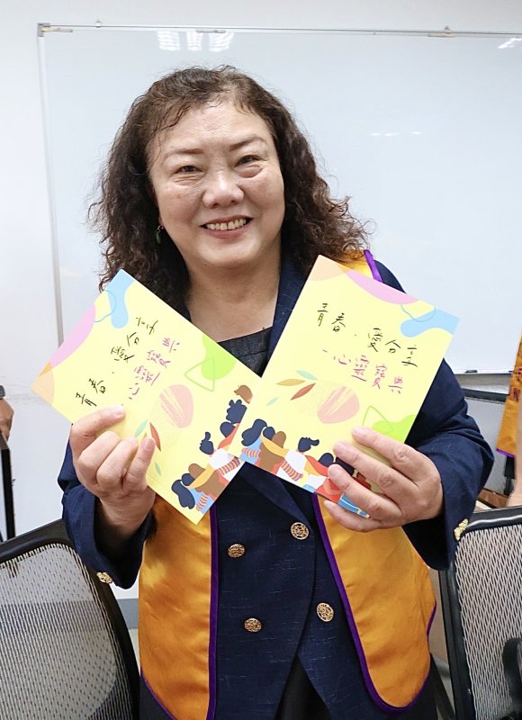 高師大獅子會會長凌錦慧出示這次所捐贈的《青春•愛分享心靈寶典》，彙整20項核心議題，讓抽象的情緒有了出口，也讓迷惘的青春找到方向。