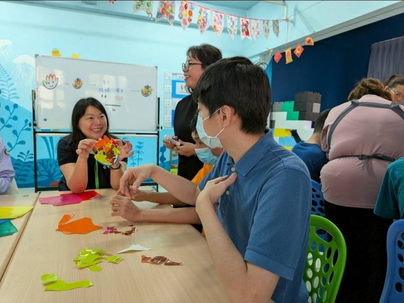台電高雄區處業務副處長許佳玉(左1)與照顧中心的星兒們一起做手掌撕貼創作。