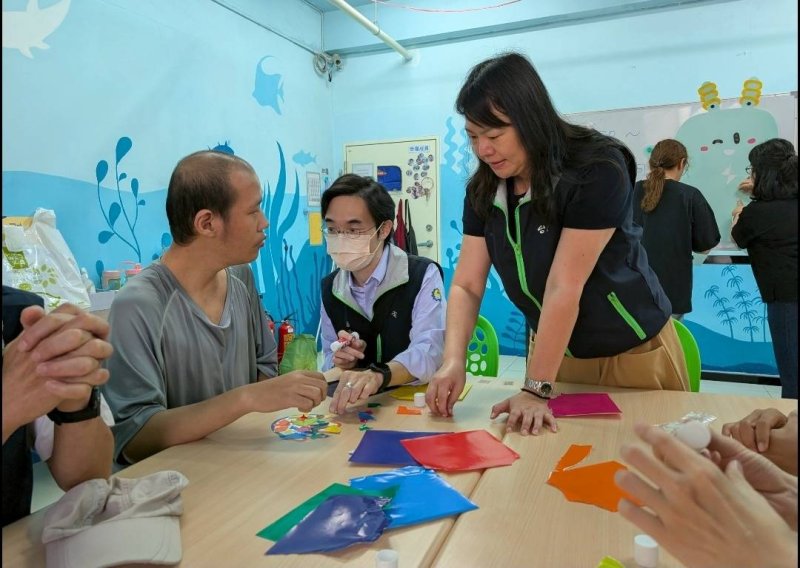 台電高雄區處業務副處長許佳玉(右1)在4/2世界自閉症關懷日前夕，到星星兒社會福利基金會大同社區照顧中心和星兒一起完成手掌撕貼創作。