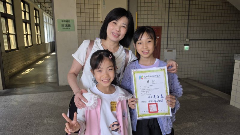 拿下國小高年級第一名的七賢國小美術班五年級蘇芝嫻與獲得國小低年級組入選的大榮國中蘇容萱，與媽媽蔣佳樺開心合影。(漾新聞記者陳雯萍攝)