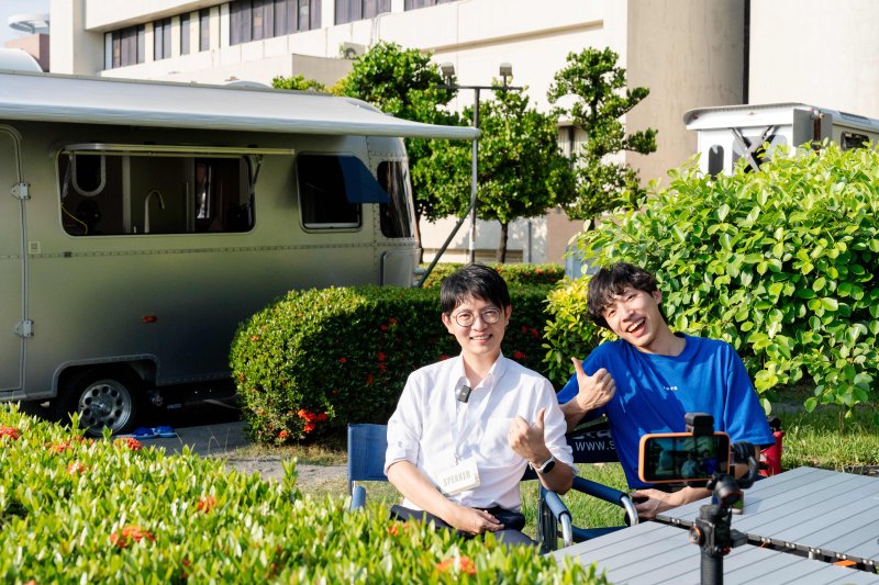 高雄青年局長林楷軒(左)與「nuva」創辦人林上哲(右)於巡迴露營車旁錄製Podcast,進一步交流AI教育推廣與青年自主學習趨勢。 高雄青年局長林楷軒(左)與「nuva」創辦人林上哲(右)於巡迴露營車旁錄製Podcast,進一步交流AI教育推廣與青年自主學習趨勢。