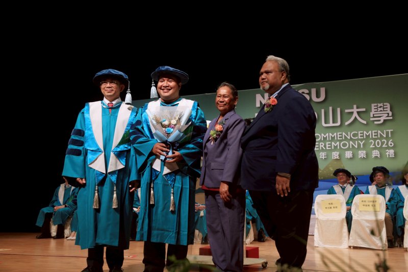 中山大學首位即將畢業的帛琉籍博士生艾博內（左二），獲帛琉共和國駐台代辦歐儒侃（右一）親自到場獻花祝賀。