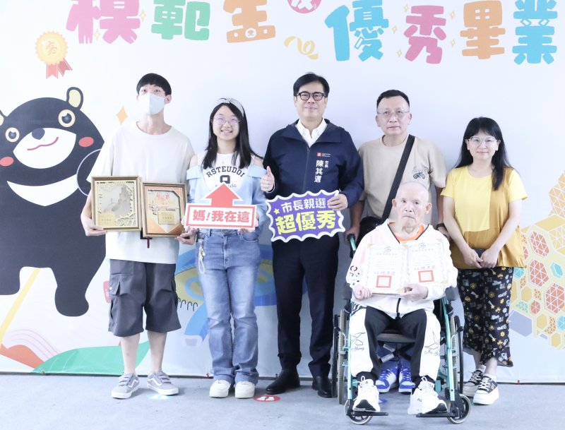 普門中學模範生戴明愛(左二)邀請家人一同與市長合影,89歲的爺爺坐著輪椅特地到場,開心拿著孫女的獎狀分享榮耀。 普門中學模範生戴明愛(左二)邀請家人一同與市長合影,89歲的爺爺坐著輪椅特地到場,開心拿著孫女的獎狀分享榮耀。