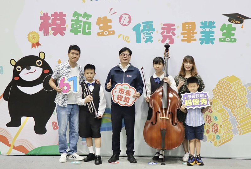 楠梓國小管樂班模範生戴昀婕（右二）來自音樂家庭，特別抱著最喜愛的低音提琴，與家人及市長陳其邁留下珍貴合影。
