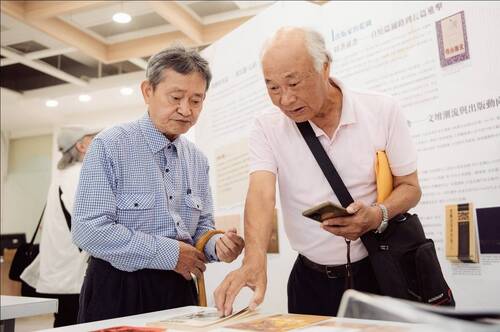 .春暉出版社陳坤崙社長為高雄市文藝協會榮譽理事長林仙龍導覽「造書者」特展，從大業書店、三信出版社和春暉出版社的發展，映照出高雄文學的發展軌跡。圖／高雄市立圖書館提供