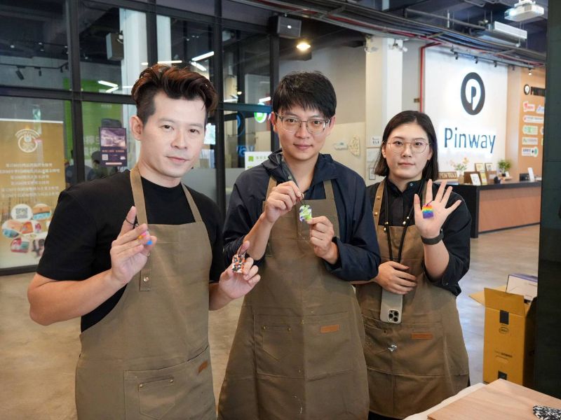 在樹德科大產設系教授傅首僖（左）及講師王喻萱（右）的引領下，高雄市青年局長林楷軒（中）體驗以回收瓶蓋製作美學與質感兼具的創意御守。