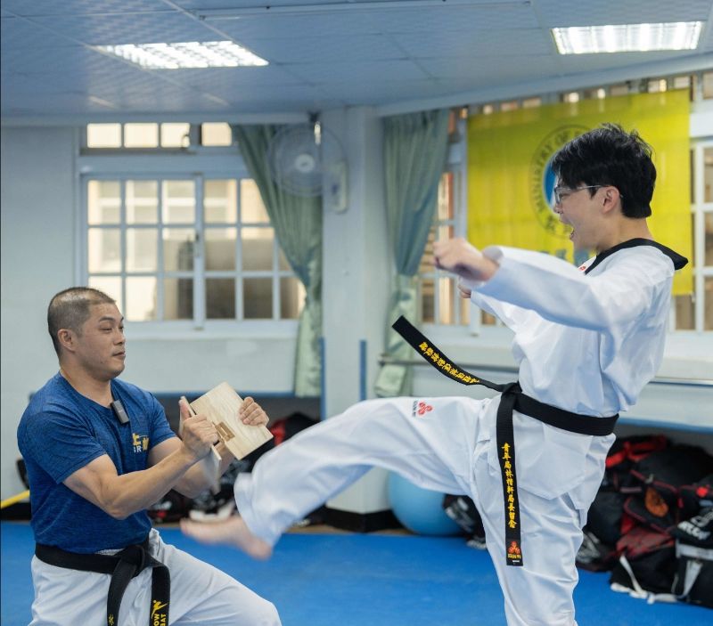 青年局長林楷軒（右）在青創業者「上如多元體適能運動館」創辦人林詠惇（左）教練的指導下，首次嘗試跆拳道踢板擊破動作。