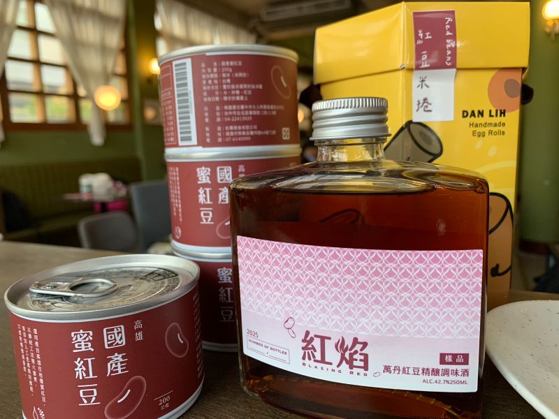 圖／高科大水食系教授侯智耀執行農業部農糧署計劃，針對國產紅豆投入創新應用的研發。圖中前排右為東海大學食品科學系副教授邱致穎在俄烏戰爭初爆發時因大麥小麥全球缺貨，創意發想利用紅豆所富含的澱粉質與小麥占比各半釀製的威士忌酒品。前排左則為高科大水食系教授侯智耀開發的蜜紅豆產品於無印良品上架，目前全國通路均缺貨中。後排右側黃色包裝則為蛋捲產品。（高科大提供）